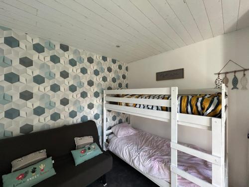 une chambre avec un lit superposé et un lit superposé dans l'établissement Lodge des pins au coeur de la forêt d'Olonne, à Olonne-sur-Mer