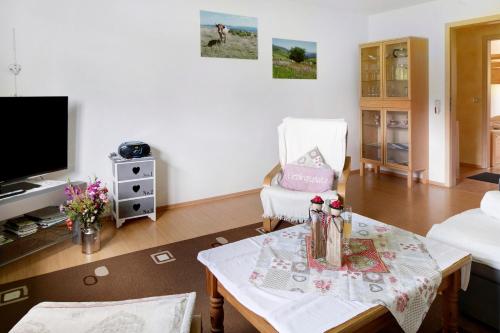 a living room with a table and a tv at Sport Rees - Ferienwohnung Melanie in Oberried