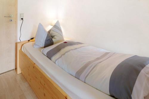 a bed with white sheets and blue pillows on it at Sport Rees - Ferienwohnung Melanie in Oberried