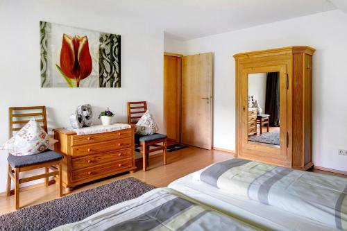 a bedroom with a bed and a dresser and a mirror at Sport Rees - Ferienwohnung Melanie in Oberried