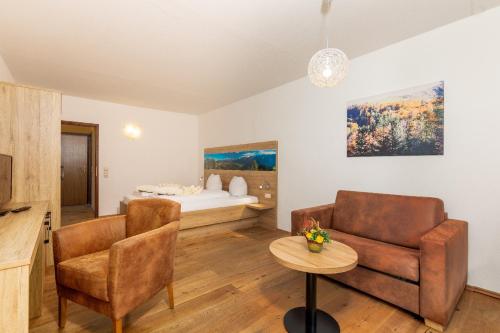 a living room with a couch and a bed at Appartementhaus Dachsteinblick mit Indoorpool und Sauna in Bad Goisern