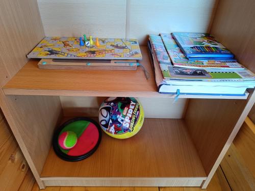 a wooden shelf with some toys and books on it at Rigaderi puhkemaja in Papsaare
