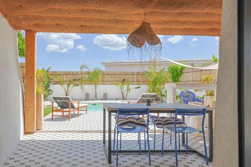 un patio avec une table et des chaises et une piscine dans l'établissement Casa Blanca, à Puget-Ville