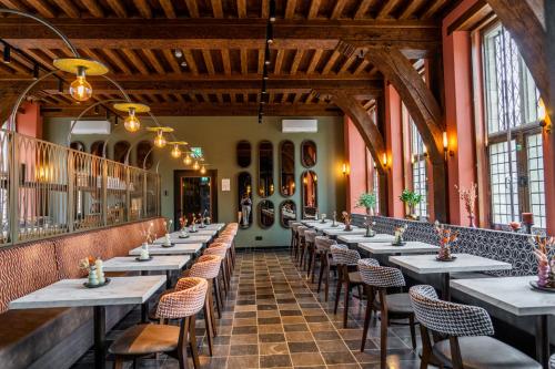 a row of tables in a room with windows at Hotel St Joris I Kloeg Collection in Middelburg