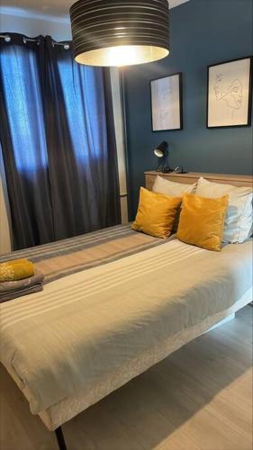 une chambre avec un grand lit avec des oreillers jaunes dans l'établissement La Canopée - Famille - 4 pers, au Havre