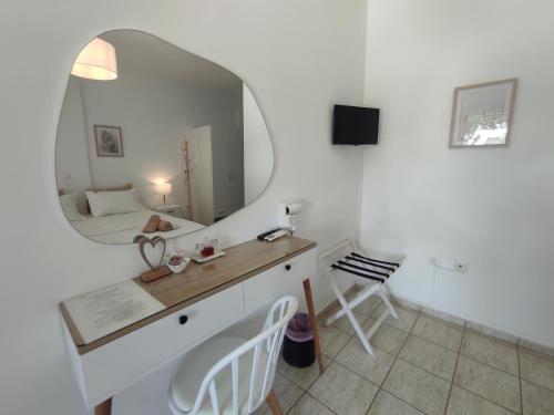 a bathroom with a mirror and a vanity with a sink at Villa Le Grand Bleu in Katapola
