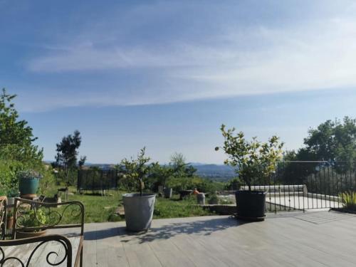 a patio with two benches and a view of a field at Piscine privative le champs des oiseaux in Vesseaux