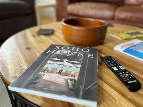 a book sitting on a table next to a remote control at Casa di Qeis a double bedroom ground floor flat with free parking in Chesterton