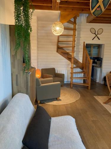 un salon avec un canapé et un escalier dans l'établissement Wissant, petite maison avec jardin proche mer, à Wissant