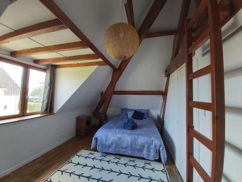 a bedroom with a blue bed in a attic at Wissant, petite maison avec jardin proche mer in Wissant