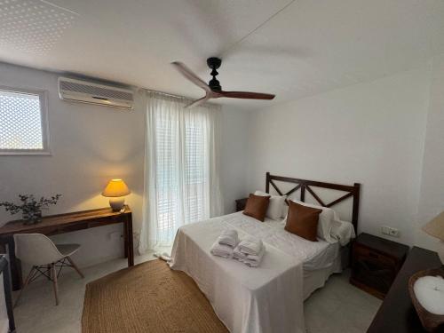 a bedroom with a bed and a ceiling fan at Casa Adosada S'Agaró in S'Agaro