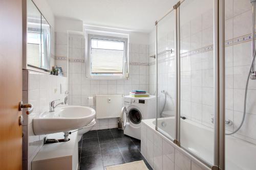 een badkamer met wastafel en wasmachine bij Haus Castellbergblick mit Balkon in Ballrechten