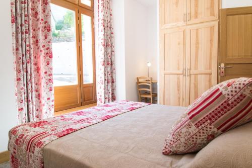 a bedroom with a bed with a window at La grange aux roses in Nojaret