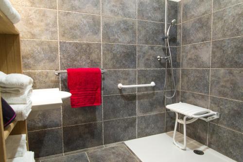 a bathroom with a shower with a red towel at La grange aux roses in Nojaret