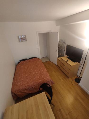 Cette petite chambre comprend un lit et une télévision. dans l'établissement Rahim, à Paris