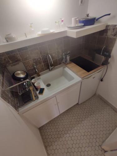 une petite cuisine avec un évier et un comptoir dans l'établissement Rahim, à Paris