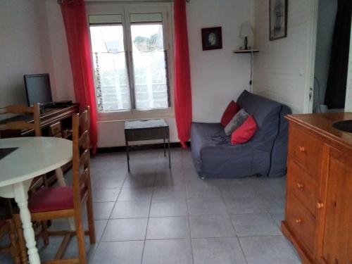 un salon avec un canapé bleu et une table dans l'établissement Maisonnette de ville proche de la grande plage, à Saint-Malo
