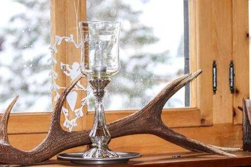 a wine glass and antlers on a table at Chalet Traumhaus in Arosa