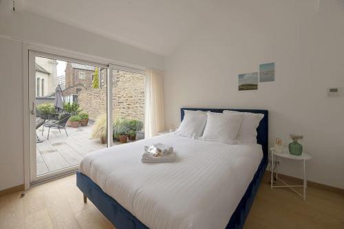 une chambre avec un grand lit et une grande fenêtre dans l'établissement Le Standing Vasselot, à Rennes