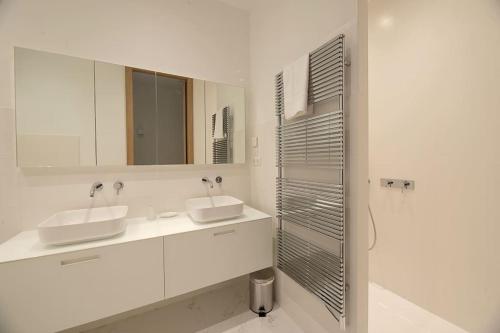 une salle de bain blanche avec deux lavabos et une douche dans l'établissement Le Standing Vasselot, à Rennes