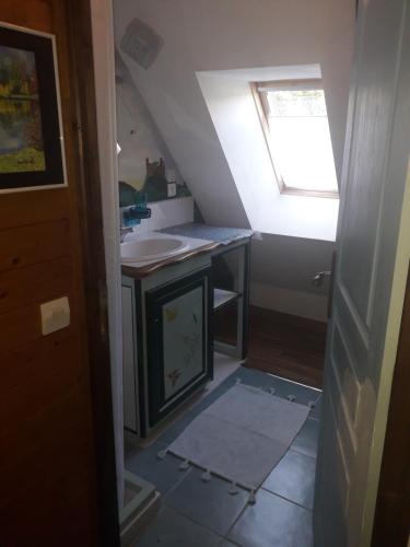 une petite salle de bain avec un lavabo et une fenêtre dans l'établissement Les 7 Lucarnes, à Latouille-Lentillac
