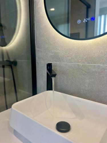 un lavabo de salle de bain avec un robinet et un miroir dans l'établissement Le Carrel, Centre de Rennes, à Rennes