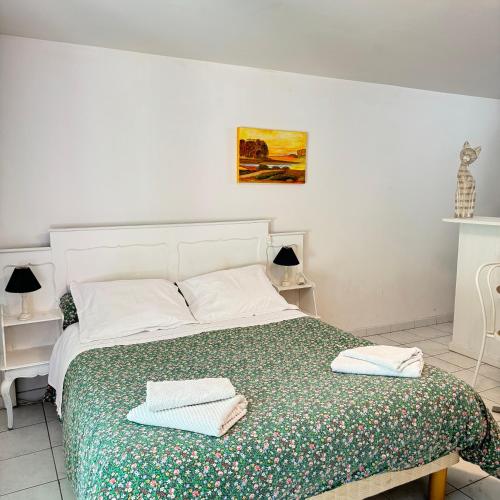 une chambre avec un lit avec deux serviettes dessus dans l'établissement Studio chaleureux au cœur du manoir, à Saint-Jouan-des-Guérets