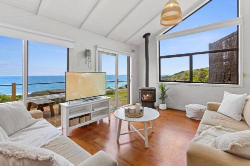 a living room with a couch and a tv and a table at 6 Whitecrest Great Ocean Road Resort - Ocean View in Apollo Bay