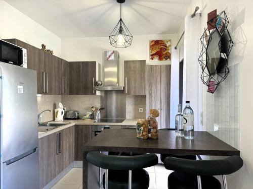 une cuisine avec une table avec des chaises et un réfrigérateur dans l'établissement Joli T2 idéalement situé, à Propriano