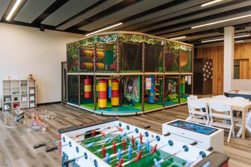 a childrens play room with a table and games at Scheiblhofer The Resort in Andau