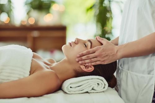 a woman getting a massage from a therapist at Garrigae Domaine de l'Esterel - piscine & SPA Cinq Mondes in Saint-Raphaël