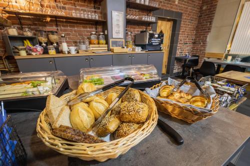 a table topped with baskets of bread and pastries at City Wohlfühloase - FeWo Berger in Bielefeld