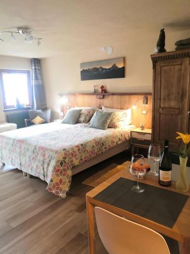 a bedroom with a bed and a table with a wine glass at Petite Maison Gaspard in Valtournenche