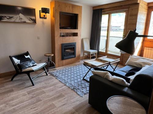 un salon avec un canapé et une cheminée dans l'établissement Appartement 3ch · 70m² · Ski aux pieds · Piscine · Animaux admis - FR-1-181-2816, à La Plagne Tarentaise