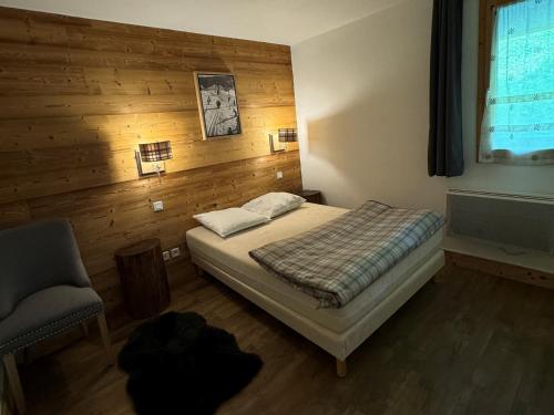 une chambre avec un lit et une chaise dans l'établissement Appartement 3ch · 70m² · Ski aux pieds · Piscine · Animaux admis - FR-1-181-2816, à La Plagne Tarentaise