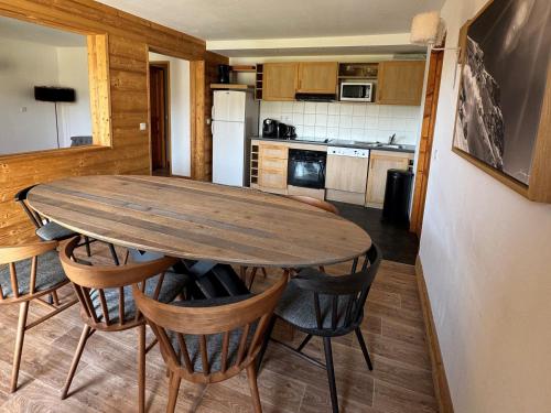 une cuisine avec une table et des chaises en bois dans l'établissement Bel appartement 4 pièces avec piscine, jacuzzi, sauna, animaux admis - FR-1-181-2818, à La Plagne Tarentaise