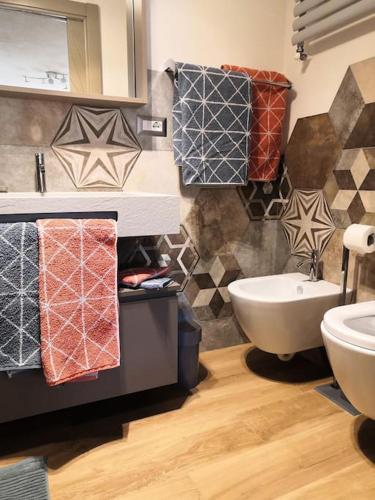 a bathroom with a sink and a toilet and towels at Petite Maison Gaspard in Valtournenche