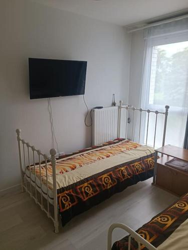 - une chambre avec un lit et une télévision murale dans l'établissement Appartement idéalement situé à Evry-Courcouronnes, Évry-Courcouronnes
