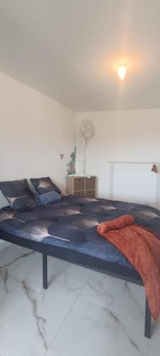 Ce lit se trouve dans un dortoir doté d'un couvre-lit bleu. dans l'établissement T2 avec vue magnifique, à Sisteron