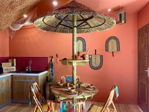 - une salle à manger avec une table et un parasol dans l'établissement Serengeti Safari Room, à Sigean