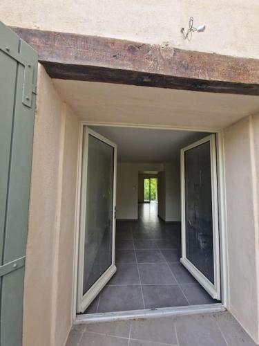 un couloir vide d'une maison avec des portes coulissantes en verre dans l'établissement La fontaine, à Saint-Didier