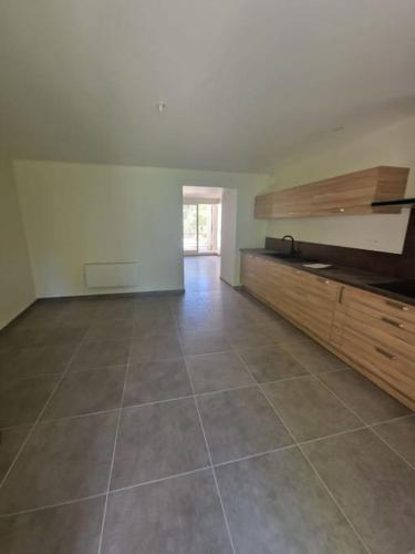 une pièce vide avec un grand carrelage et une cuisine dans l'établissement La fontaine, à Saint-Didier