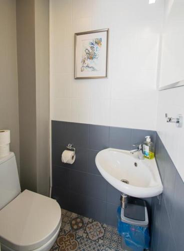 a bathroom with a white toilet and a sink at Gardenview Selection by Kerese Apartments in Pärnu