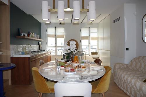 une salle à manger avec une table et un canapé dans l'établissement Luxueux Appartement avec balcon, Champs Élysées, à Paris