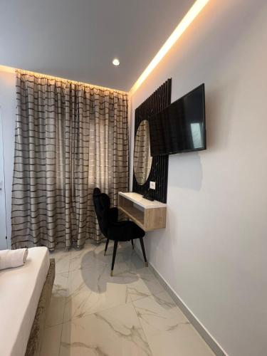 a bedroom with a desk and a television on a wall at Spahiu Guesthouse in Ksamil