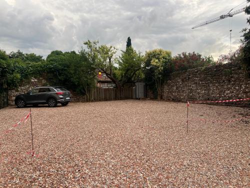 a car parked in a parking lot next to a wall at Le Casette SEI in Pacengo di Lazise