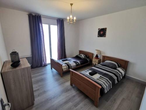 - une chambre avec 2 lits dans une chambre avec une fenêtre dans l'établissement Maison avec jardin, à Carcassonne