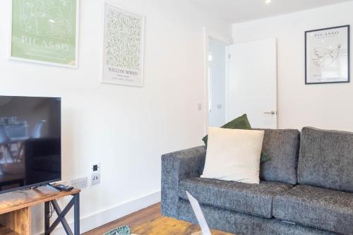 a living room with a couch and a tv at Moncrieff House in Livingston