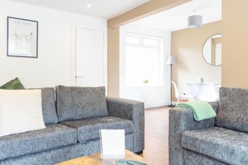 a living room with a couch and two chairs at Moncrieff House in Livingston