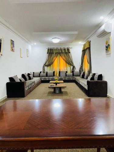 a large living room with a large wooden table at Les HOTELS TALHAYA, NOUAKCHOTT in Nouakchott